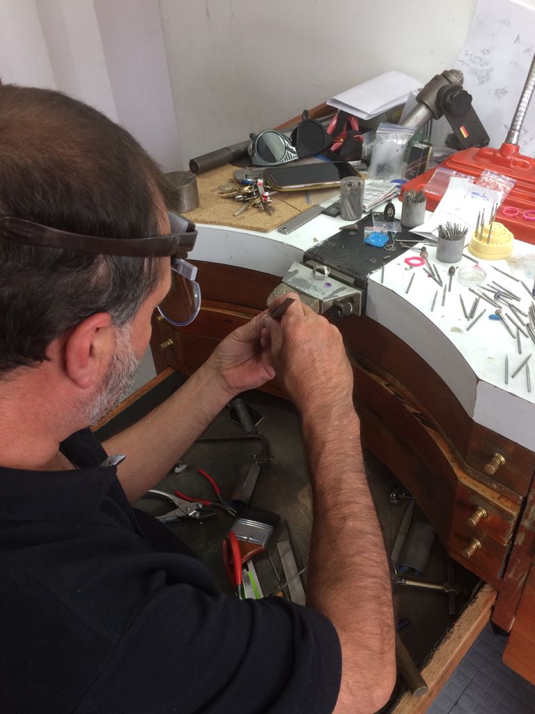 Our experience bench jeweler creating a piece of custom emerald jewelry